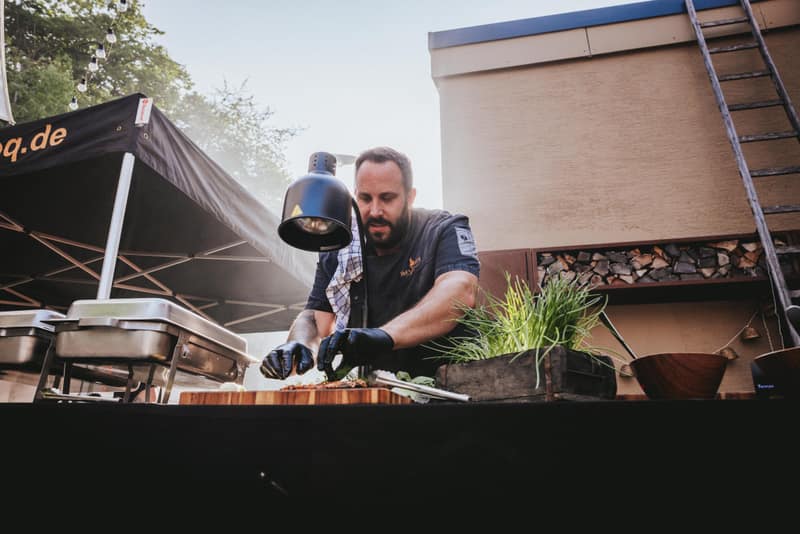 Grillmeister richtet an der Station unter dem Pavillon an