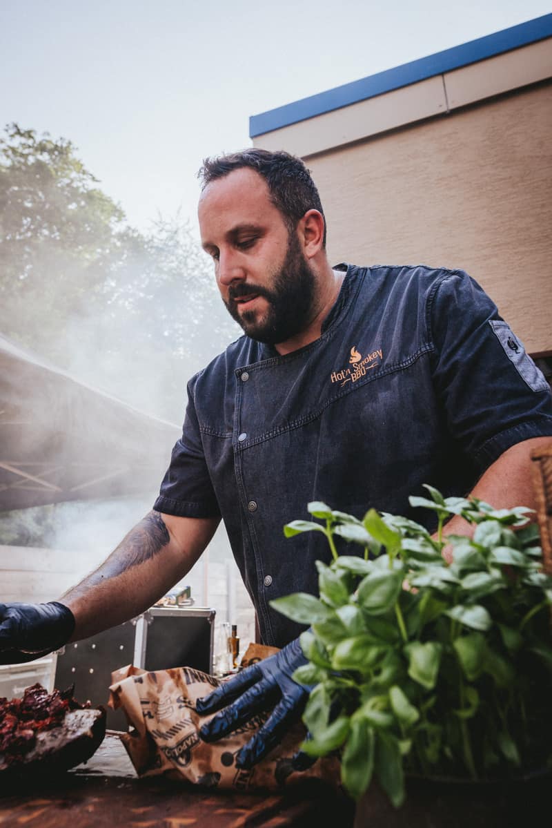 Grillmeister im Rauch, im Vordergrund Basilikum