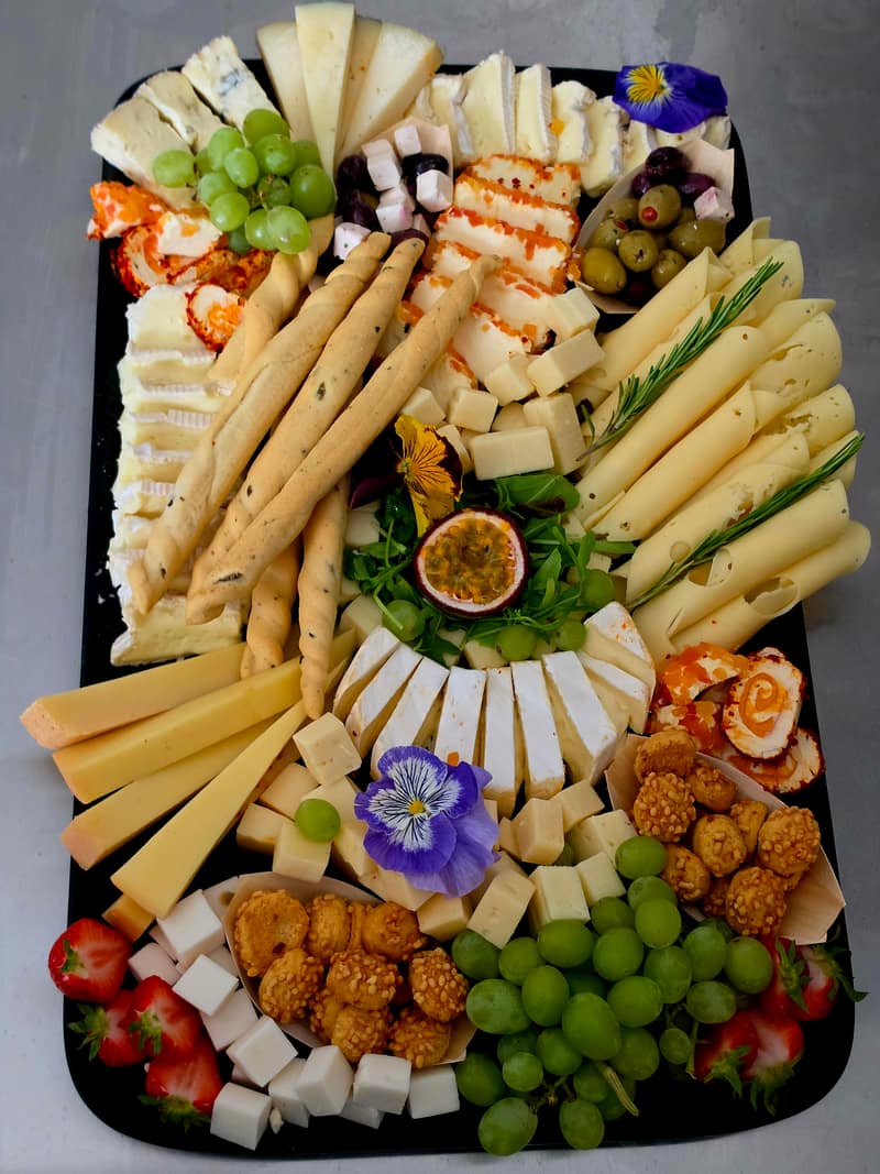 Käseplatte mit Trauben, Feigen und essbaren Blüten