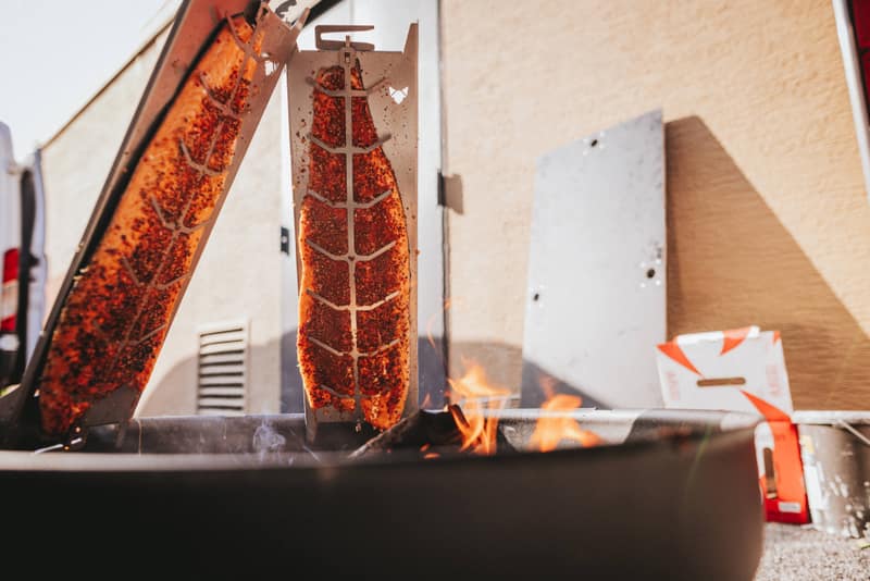 Lachs auf Holzplanken am offenen Feuer