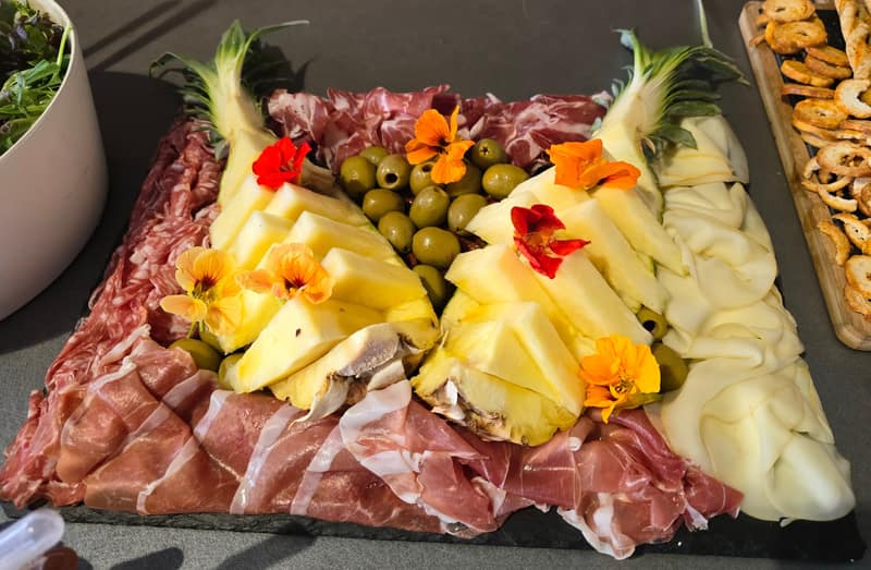 Antipasti-Platte mit Schinken, Käse, Oliven und Blüten